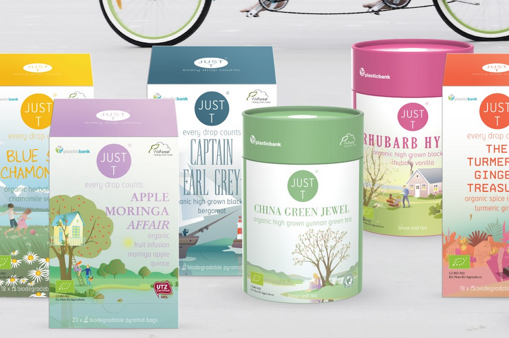 Verschiedene Teeverpackungen auf einer weißen Oberfläche mit einem Fahrrad im Hintergrund.